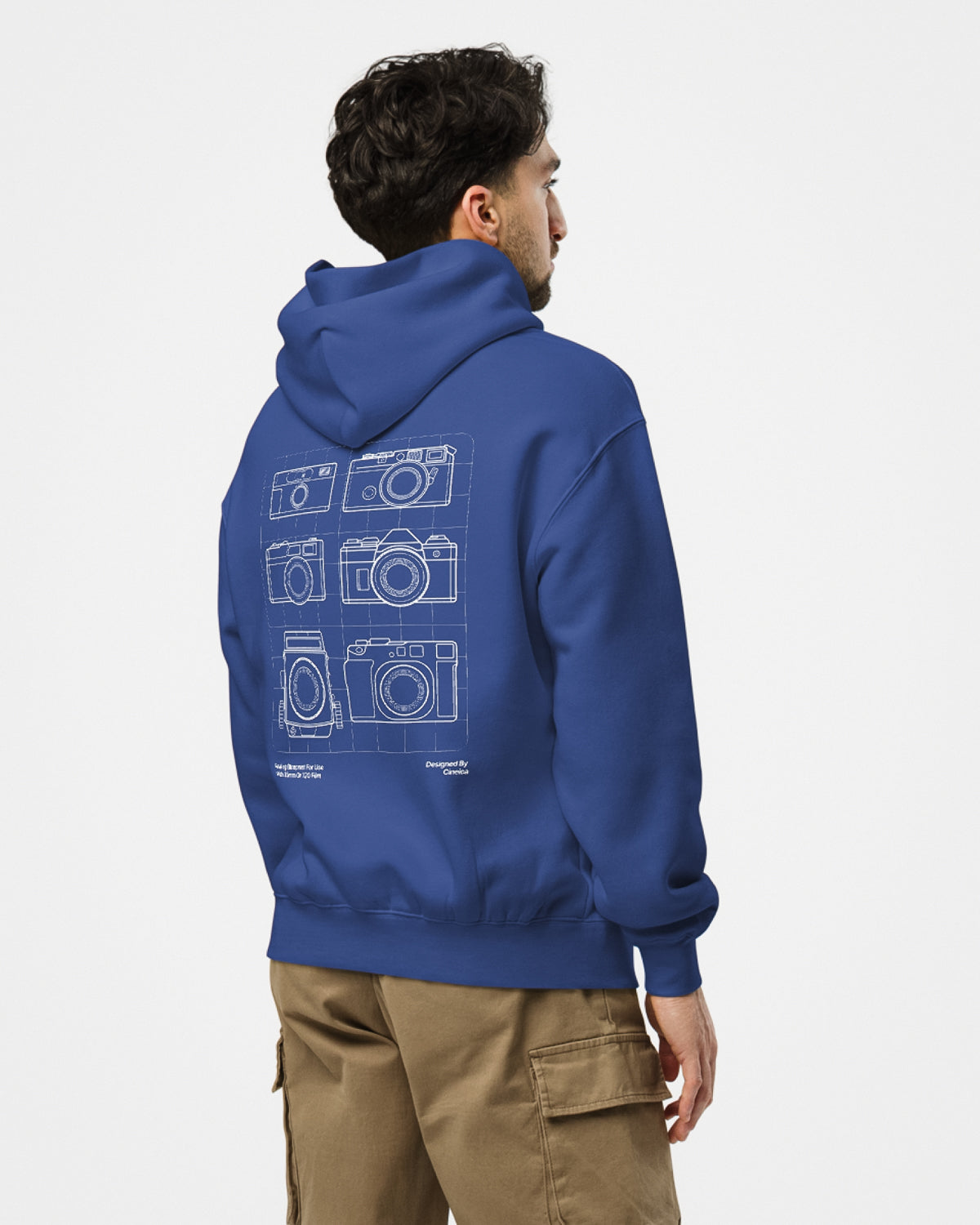 Back of man wearing a blue hoodie with white design featuring six film cameras in a blueprint style.