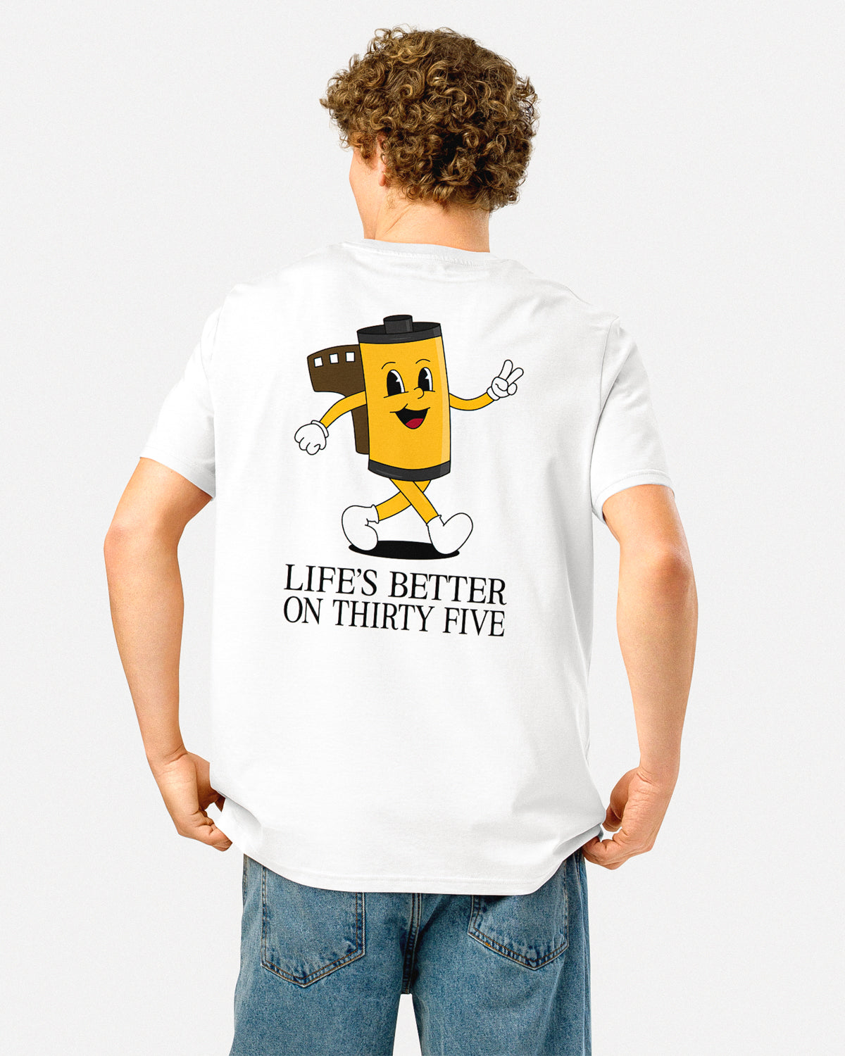 Photo of a man in a white t-shirt with a 35mm roll of film cartoon character and text "LIFE'S BETTER ON THIRTY FIVE".