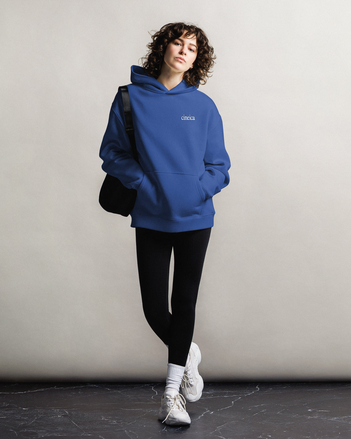 Photo of a woman wearing a blue cineica hoodie.