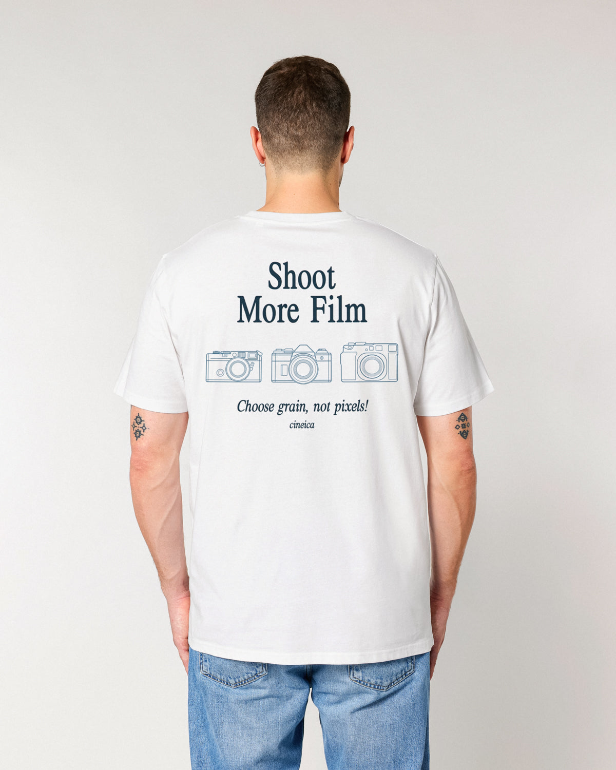 Male model wearing the Shoot More Film T-Shirt from the back, featuring three illustrated cameras and a film-inspired slogan by cineica.