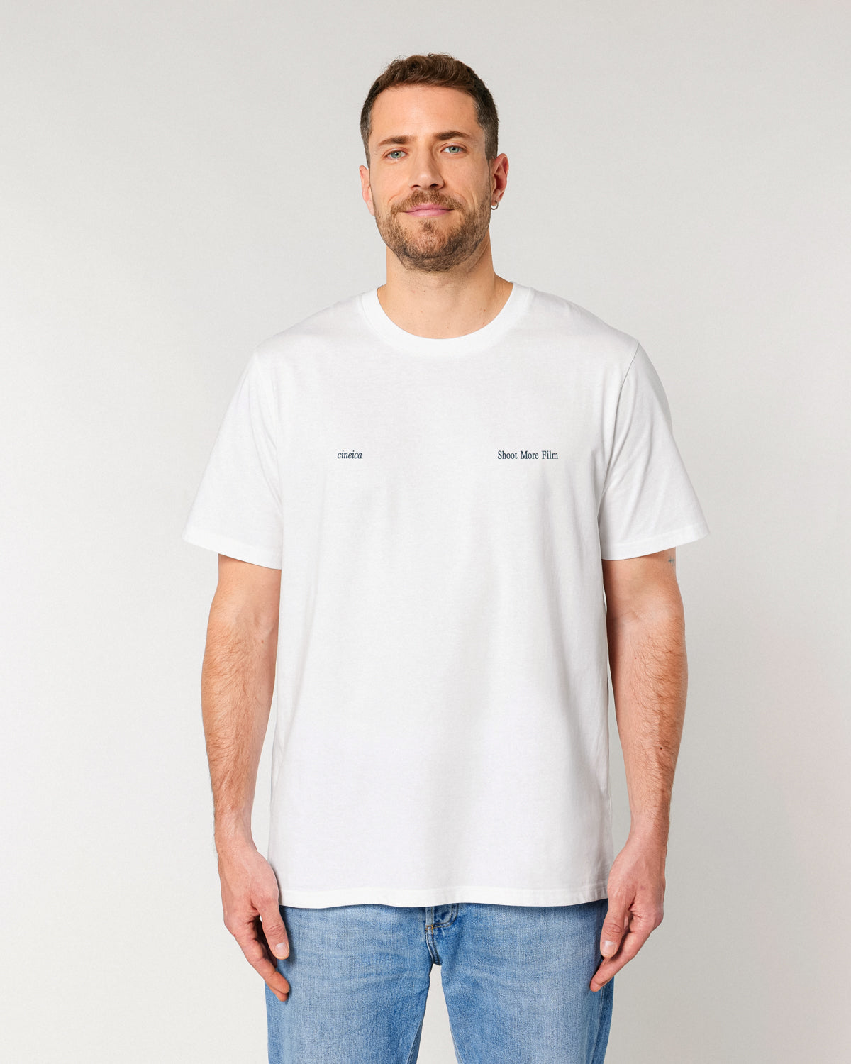 Model wearing white Shoot More Film T-Shirt with minimal front design – part of cineica’s film photography collection.