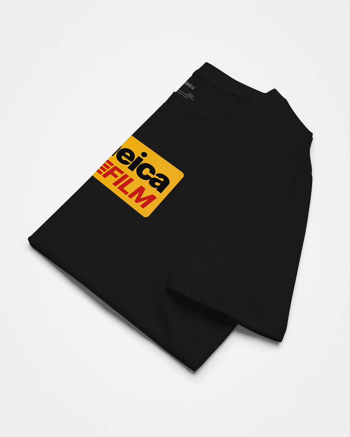A black analog photography t-shirt folded-up with vintage Kodak-styled graphic and text "cineica FILM".