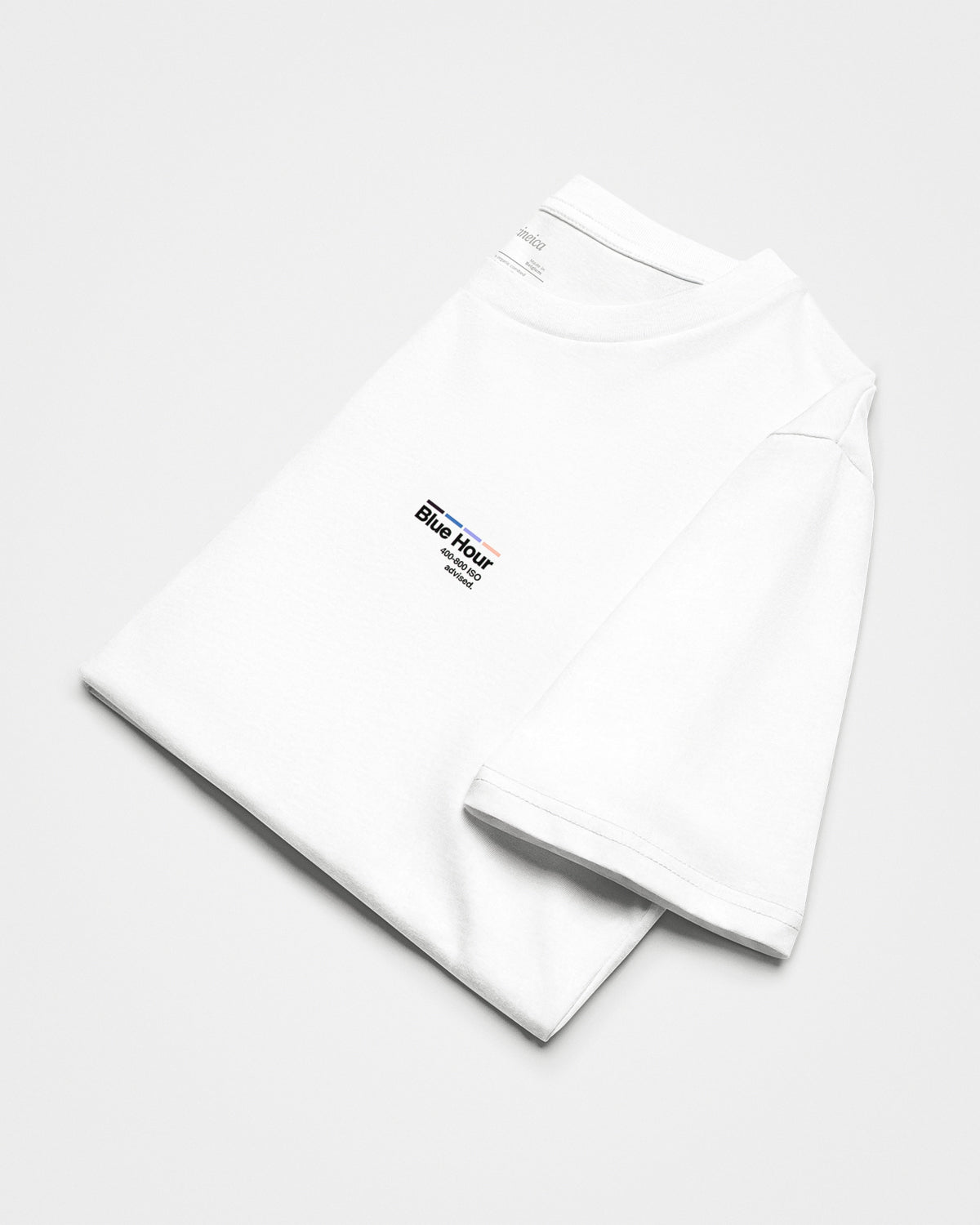 A folded white t-shirt with text "Blue Hour, 400-800 ISO advised.".
